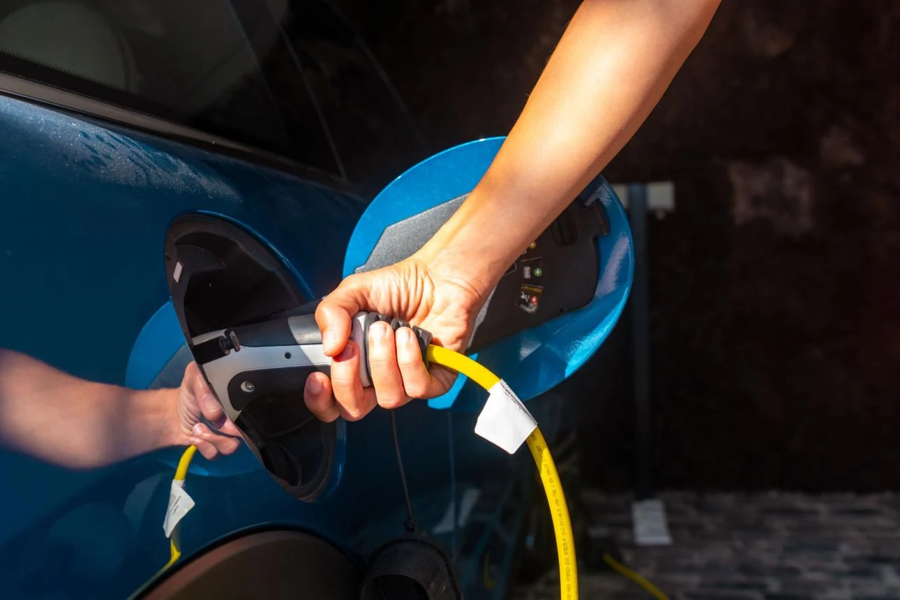 An electric vehicle charger being connected to a car.